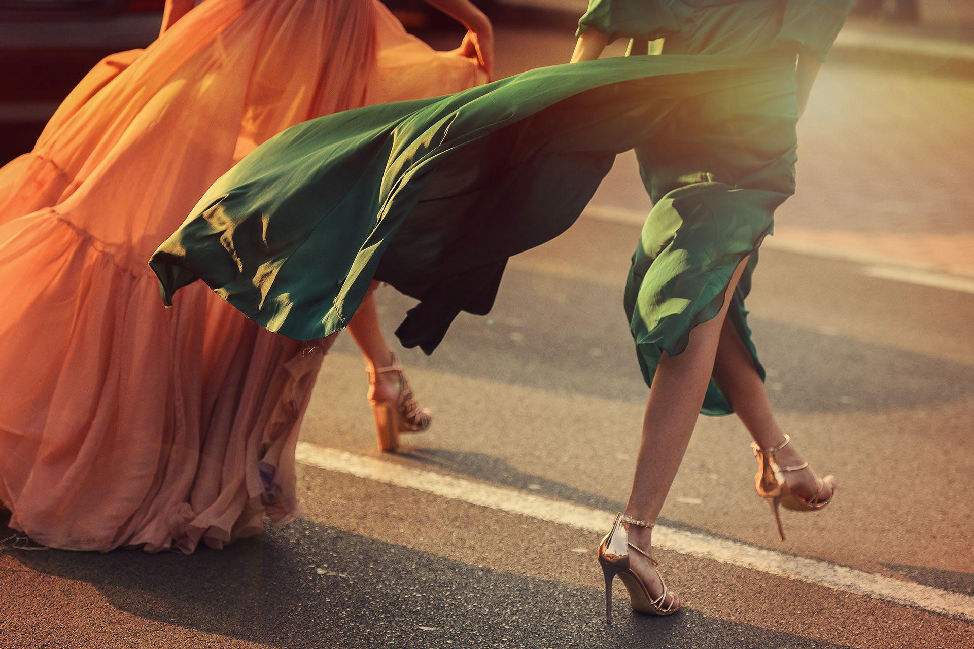 Gente con vestidos largos cruzando la calle con tacones altos