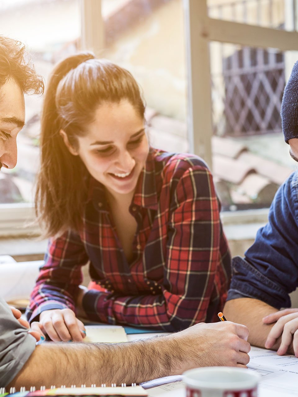 Drei Studenten arbeiten gemeinsam und lachen