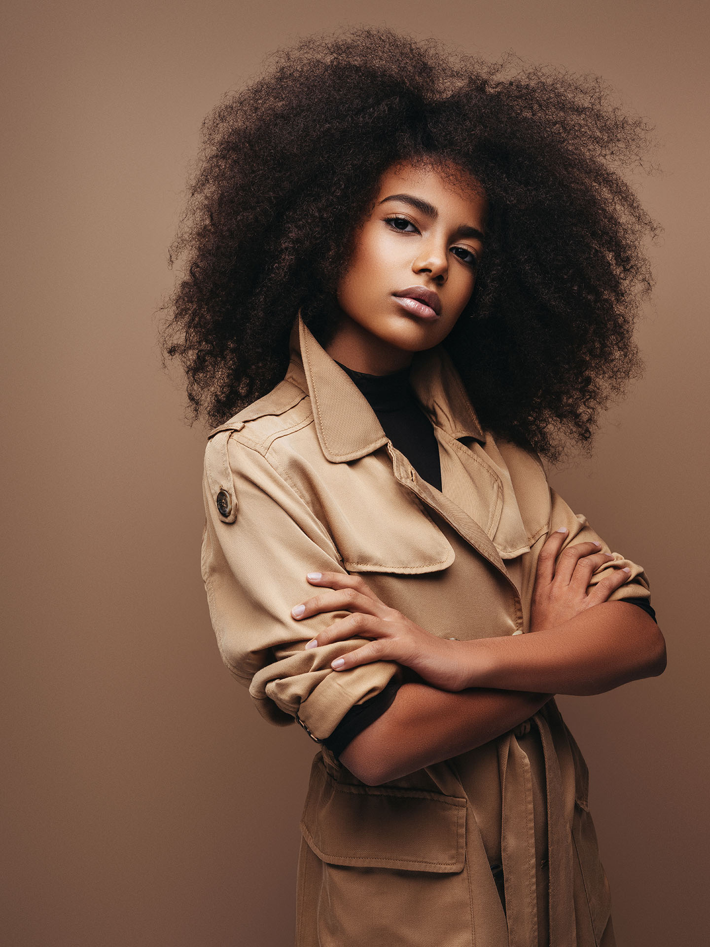 Mujer con rizos en un parker beige