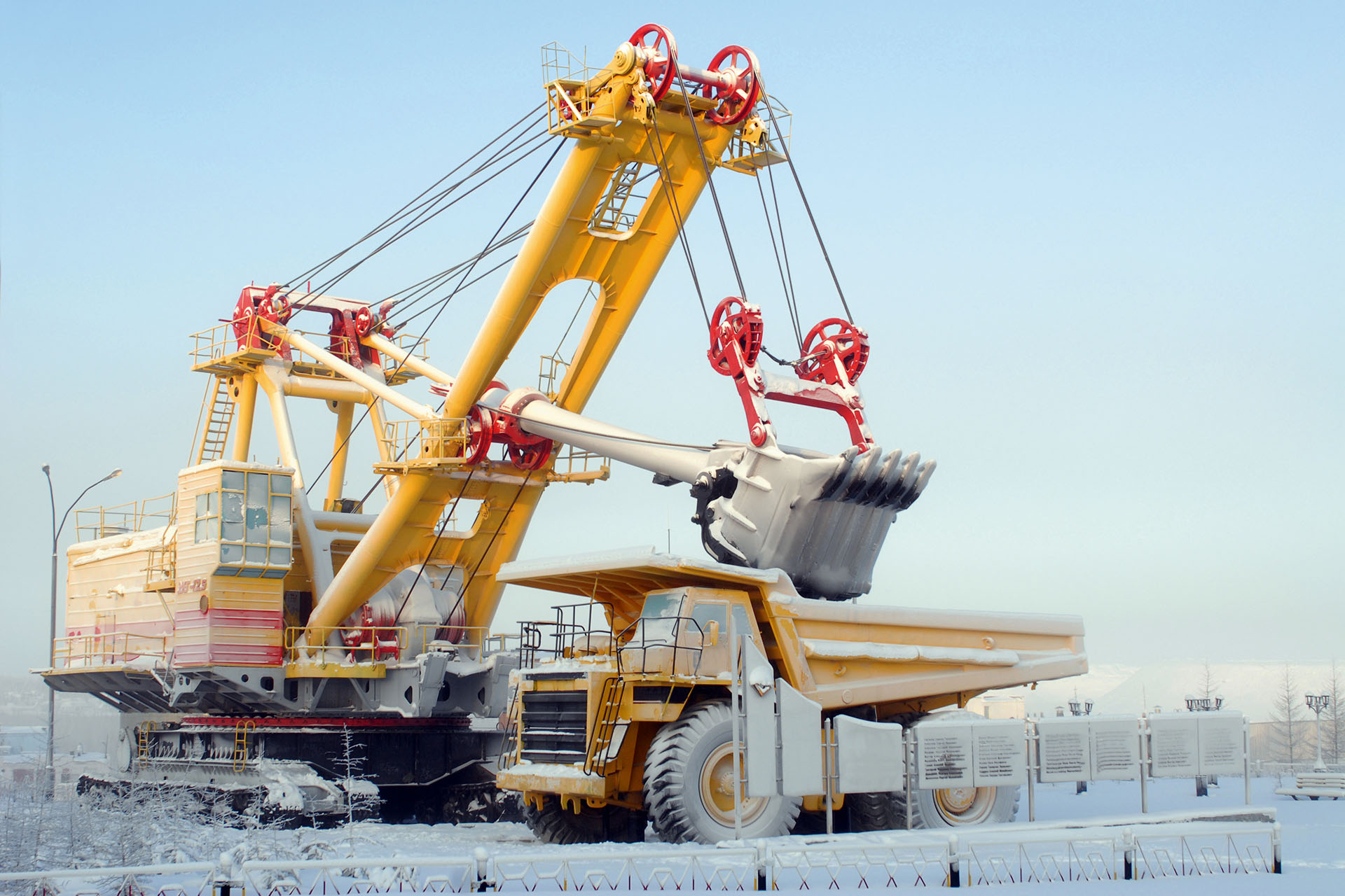 Gelber Bagger belädt gelben LKW