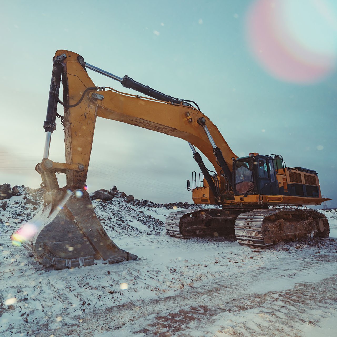 Orangener Bagger parkt im Schnee