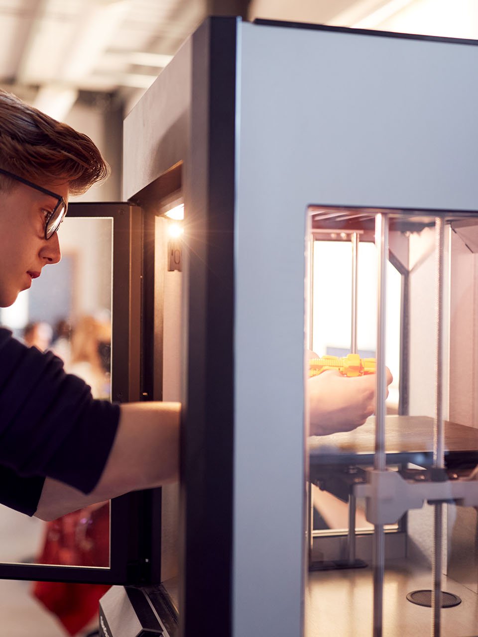 Ein junger Mann arbeitet an einem 3D-Drucker